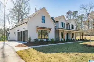 a house with a lawn and trees in the background