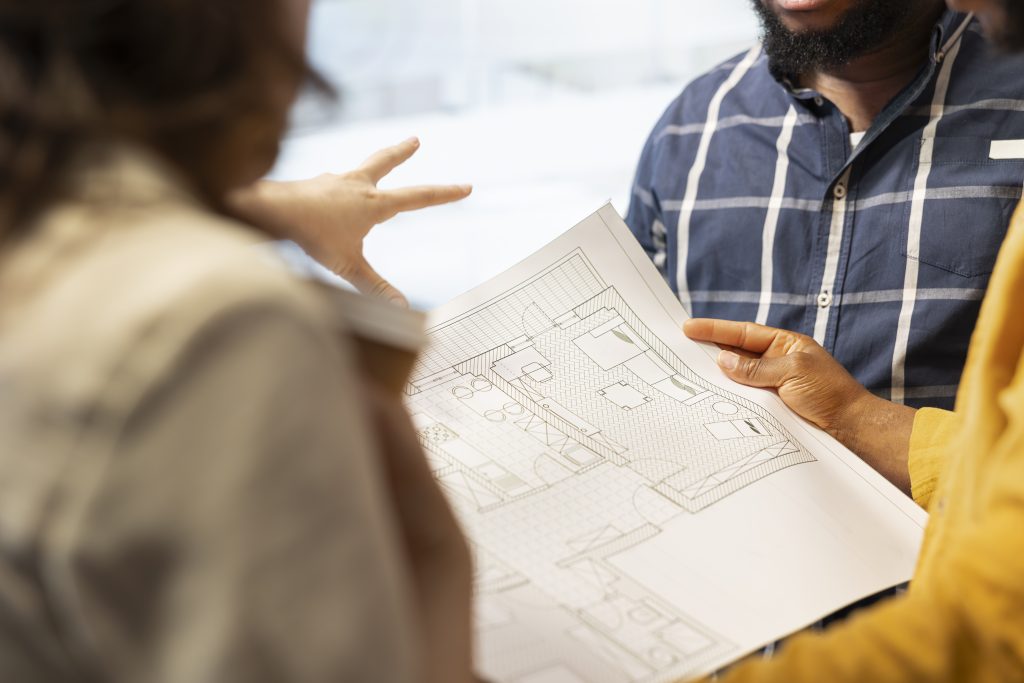a man and woman looking at a blueprint in-home consultation