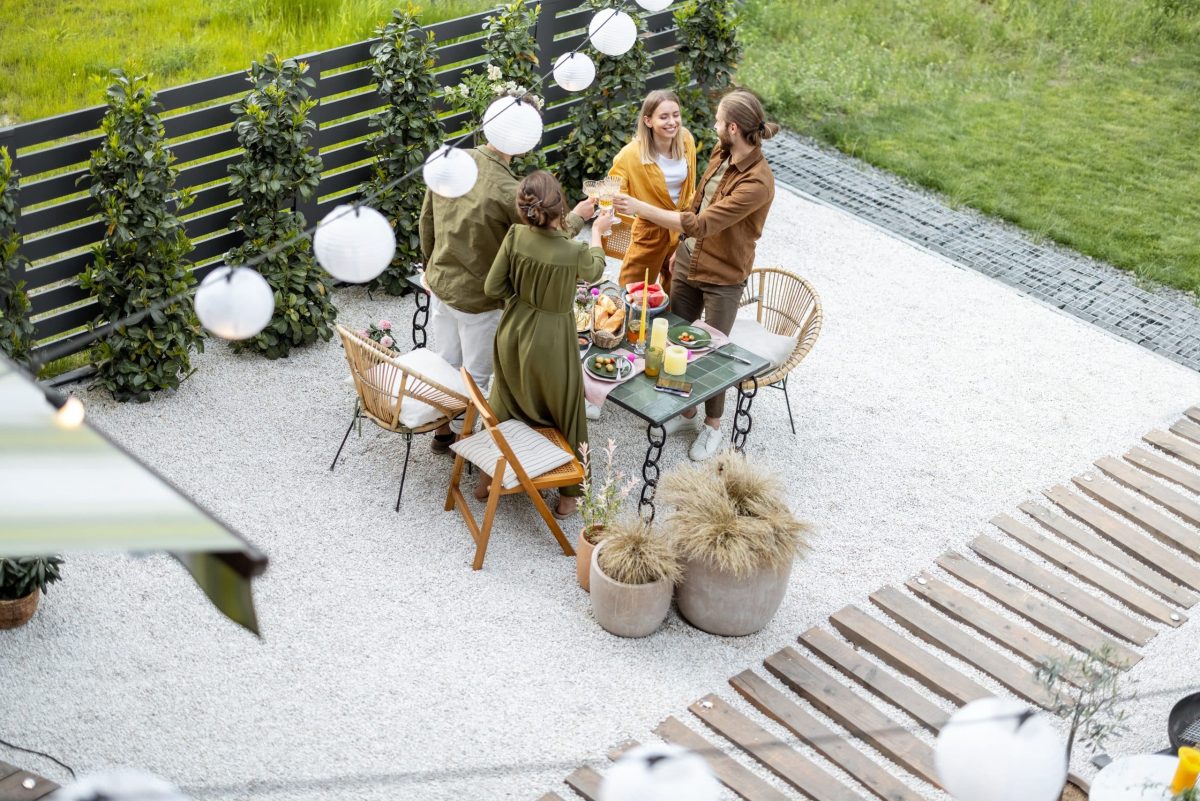 a group of people standing around a table with food and drinks