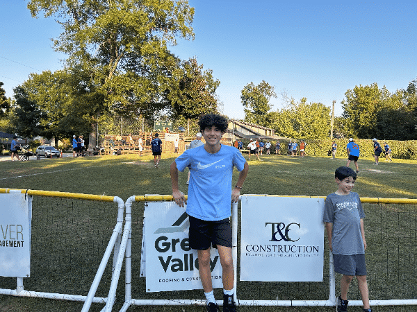 a boy standing in front of a fence